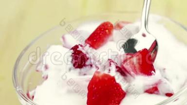 男人用<strong>勺子</strong>在透明的杯子<strong>里</strong>吃健康的草莓，配上白色酸奶，健康<strong>水果</strong>的概念